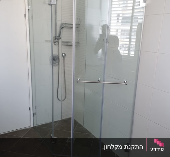 מקלחון זכוכית פינתי מותקן בחדר רחצה